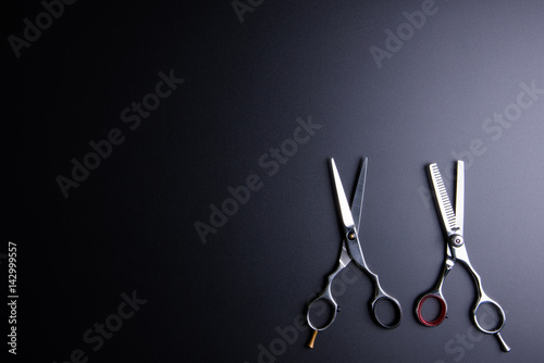 Stylish Professional Barber Scissors, Hair Cutting and Thinning Scissors on black background. Hairdresser salon concept, Hairdressing Set. Haircut accessories. Copy space image, flat lay.