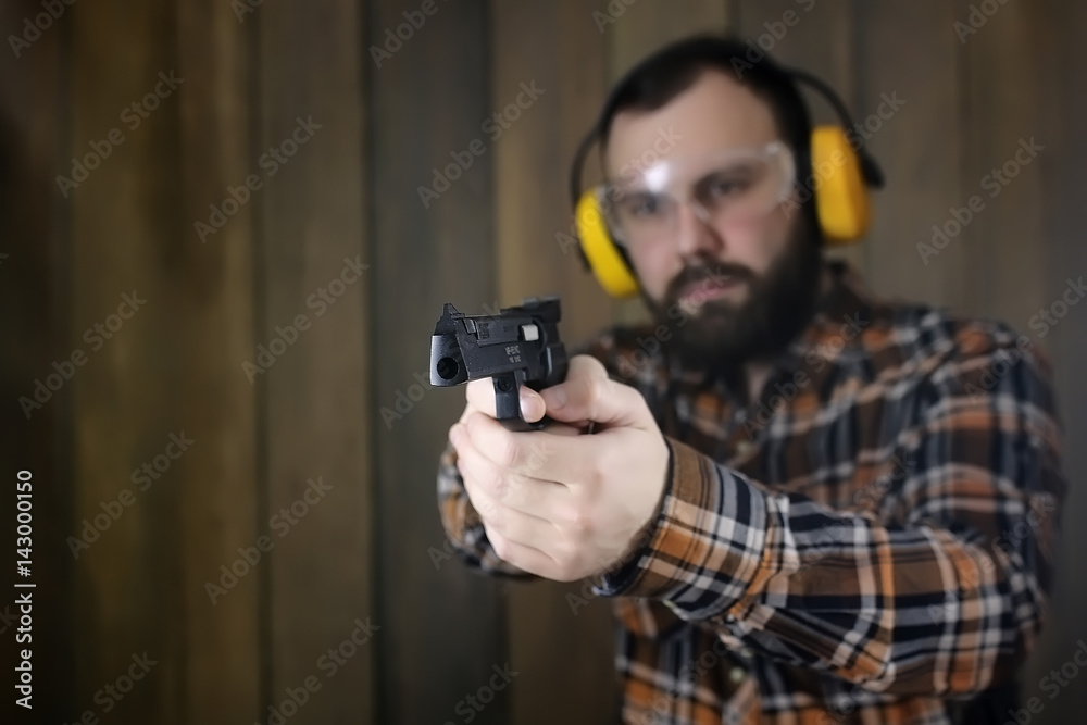 man with put on protective goggles and ear training in pistol sh man with put on protective goggles and ear training in pistol sh