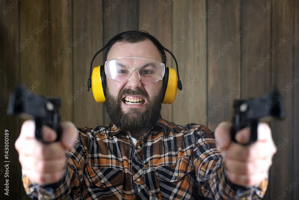 man with put on protective goggles and ear training in pistol sh man with put on protective goggles and ear training in pistol sh