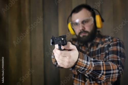 man with put on protective goggles and ear training in pistol sh