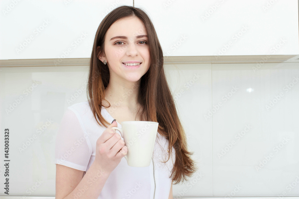 young woman With black hairdrinking coffee in the kitchen young woman With black hairdrinking coffee in the kitchen