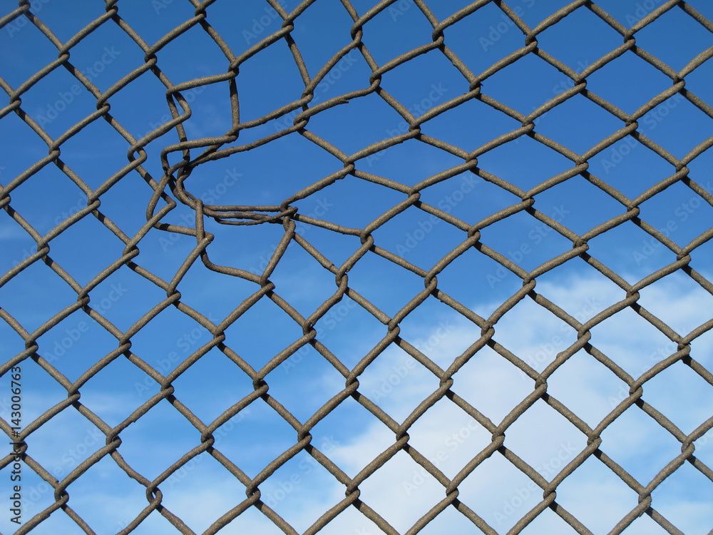 Naklejka premium .......verja metálica con agujero más ancho y fondo azul del cielo