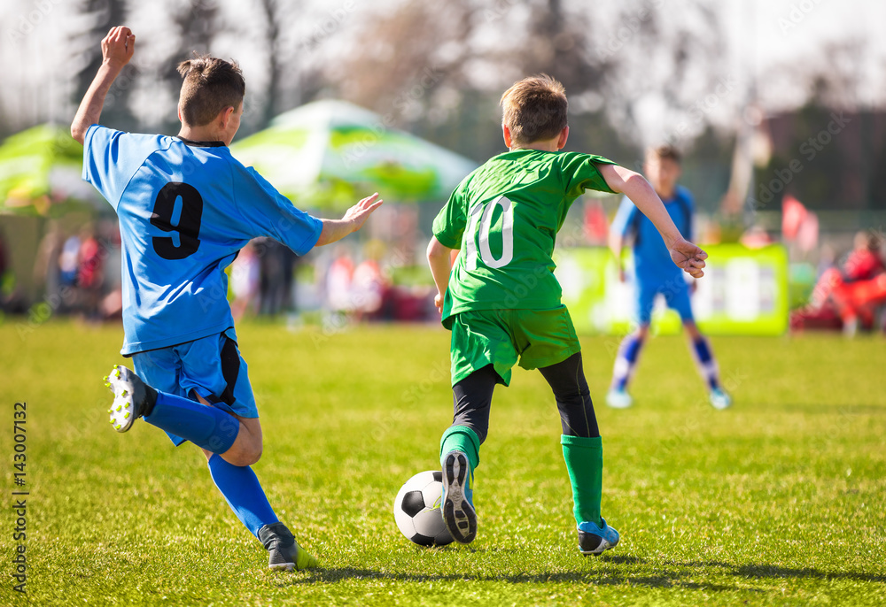Obraz premium Football soccer match. Running soccer player. Training and game for children. Youth soccer league.