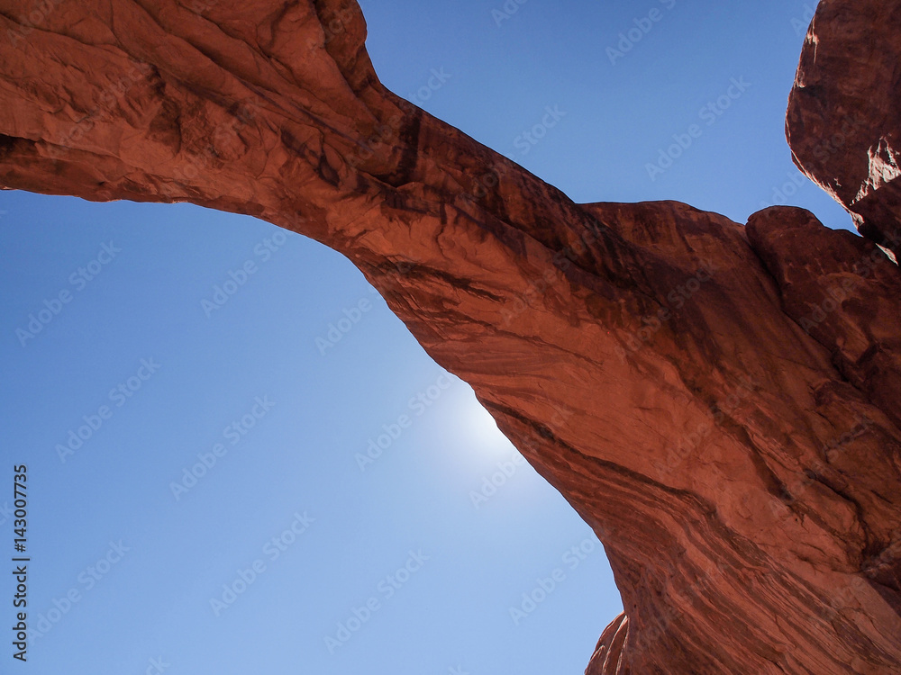 Sun behind natural arch formation at Arches National Park, Utah, United States of America