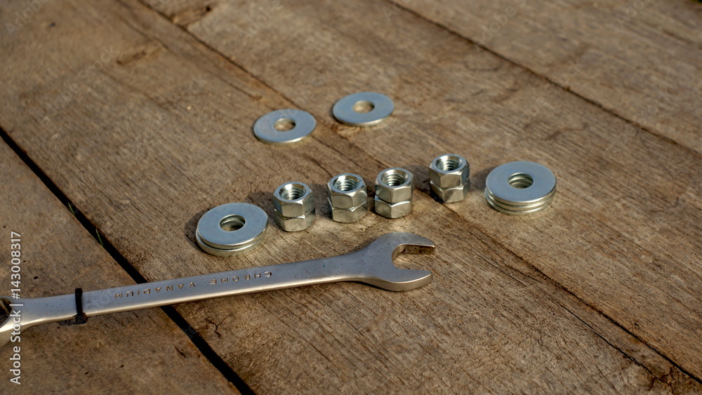 wrench nut and washers on a wooden table, focus wrench nut and washers on a wooden table, focus