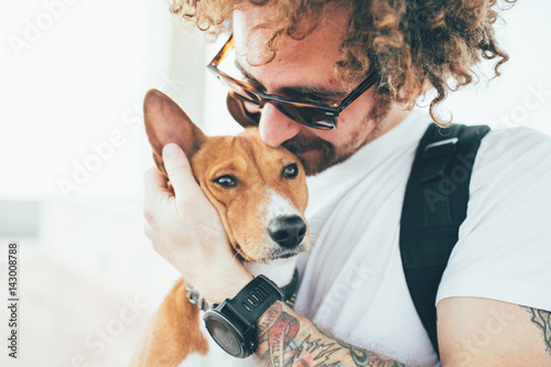 Fotografia Young trendy hipster with tattoos crazy curly hair with his best friend a cute s