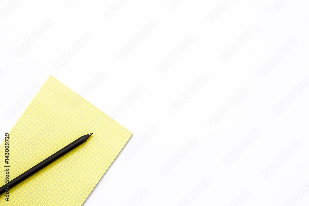 yellow notebook and black pencil on a white background. yellow notebook and black pencil on a white background.