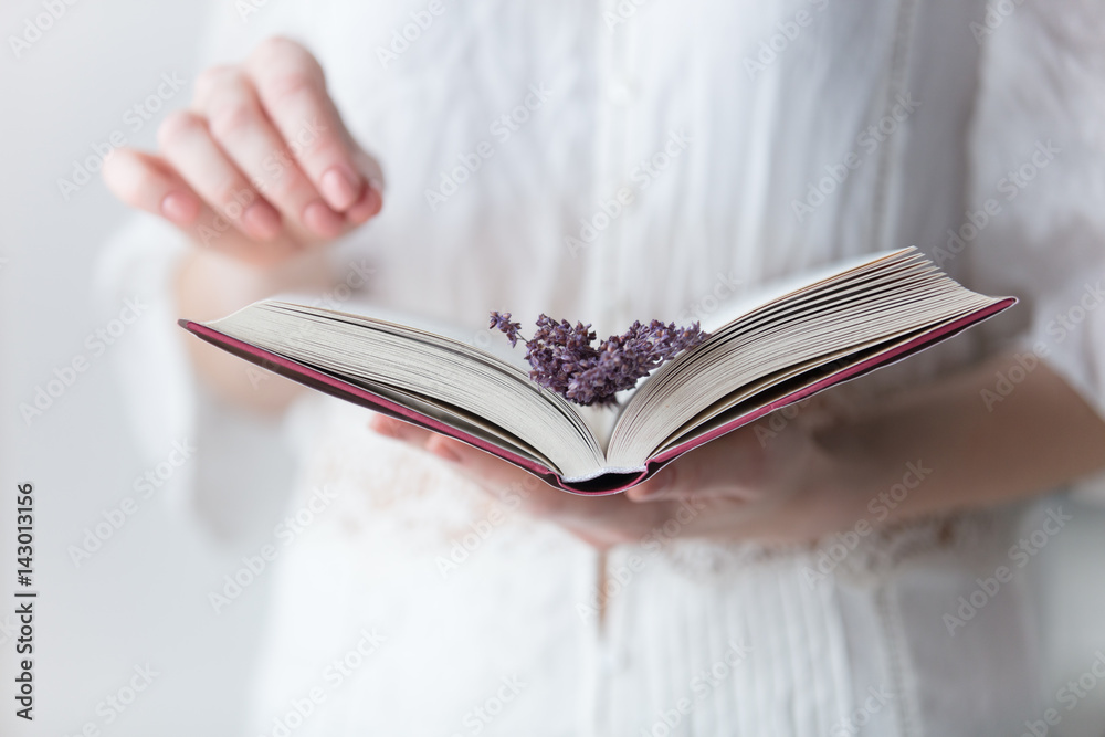 Φωτογραφία photo of young woman holding opened book with branch of lavender on the wonderfu