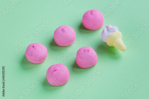 photo of tasty pink and ice cream shaped marshmallows on the wonderful green studio background