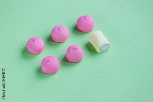 photo of tasty pink and yellow marshmallows on the wonderful green studio background