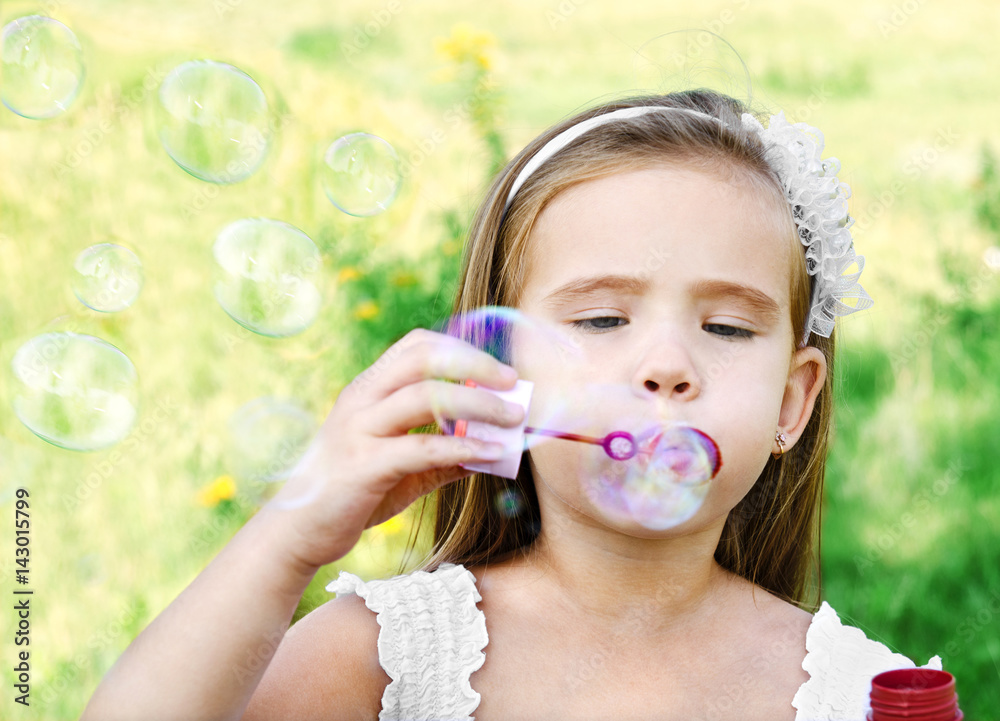 Cute little girl is blowing a soap bubbles Cute little girl is blowing a soap bubbles