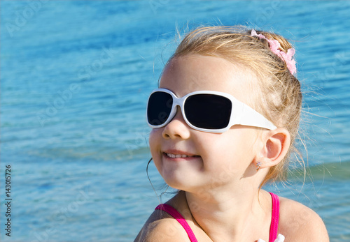 Adorable smiling little girl on beach vacation