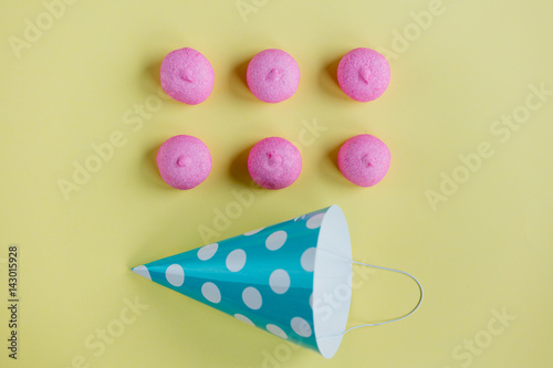 photo of tasty marshmallows and Birthday hat on the wonderful yellow background
