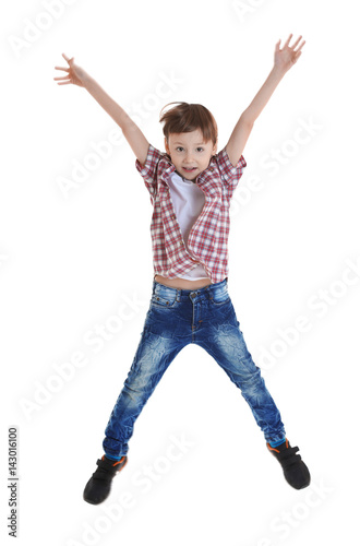Cute boy jumping on white b...