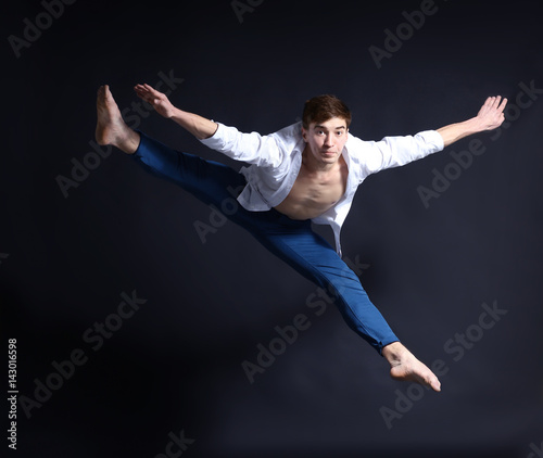 Handsome young ballet dancer on dark background