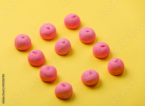 photo of tasty pink marshmallows on the wonderful yellow background