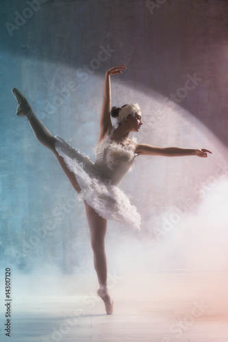Fototapeta Naklejka Na Ścianę i Meble -  Young beautiful ballerina dancing in studio with smoke effect
