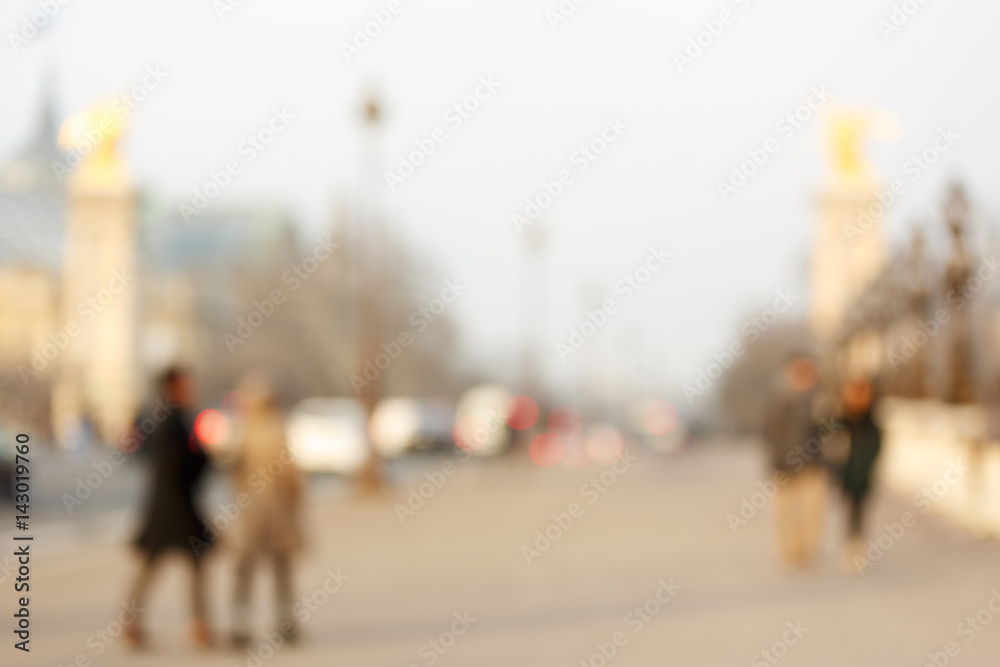 People walking on the Alexandre III Bridge in Paris, which is one of the most famous and beautful bridge in the city..The photo is purposely shot  out of focus