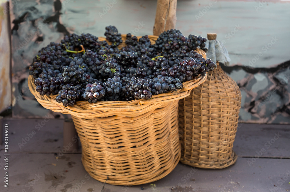 Φωτογραφία bunches of red grapes in a wicker basket and carboy