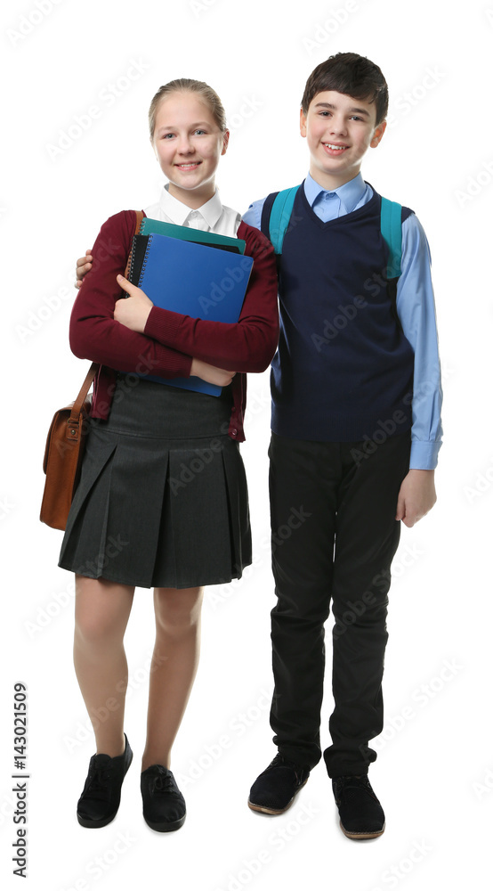 Cute boy and girl in school uniform standing on white background Cute boy and girl in school uniform standing on white background
