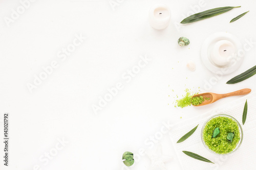 Spa composition. Candles, green leaves, flowers, green sea salt on white background. Flat lay, mock up. top view