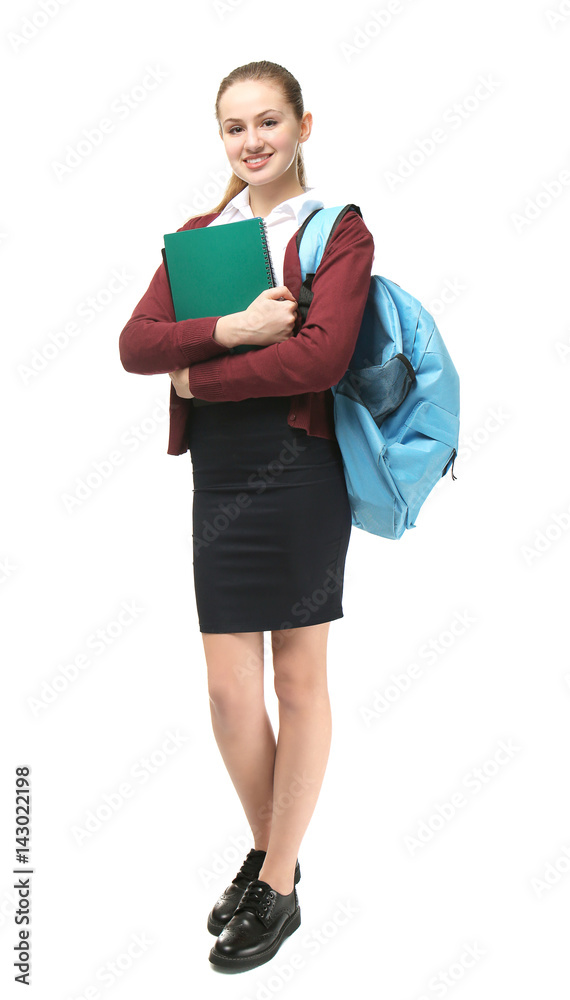 Beautiful schoolgirl in uniform standing on light background