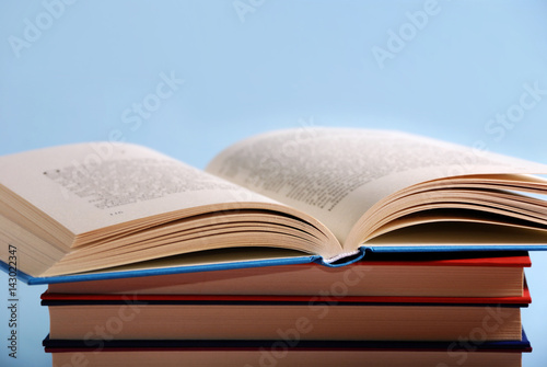 Pile of books with an open book like a background