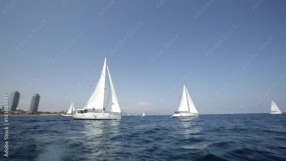 Many sailboats go under white sails on the blue sea around the island, clear blue sky, great warm summerday. Vacation and recreation concept. Active lifestyle. Many sailboats go under white sails on the blue sea around the island, clear blue sky, great warm summerday. Vacation and recreation concept. Active lifestyle.