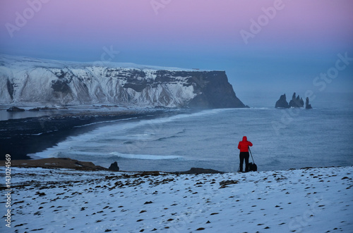 Photographer taking a photo of famous rock in vik, Icelend - after sunset colors