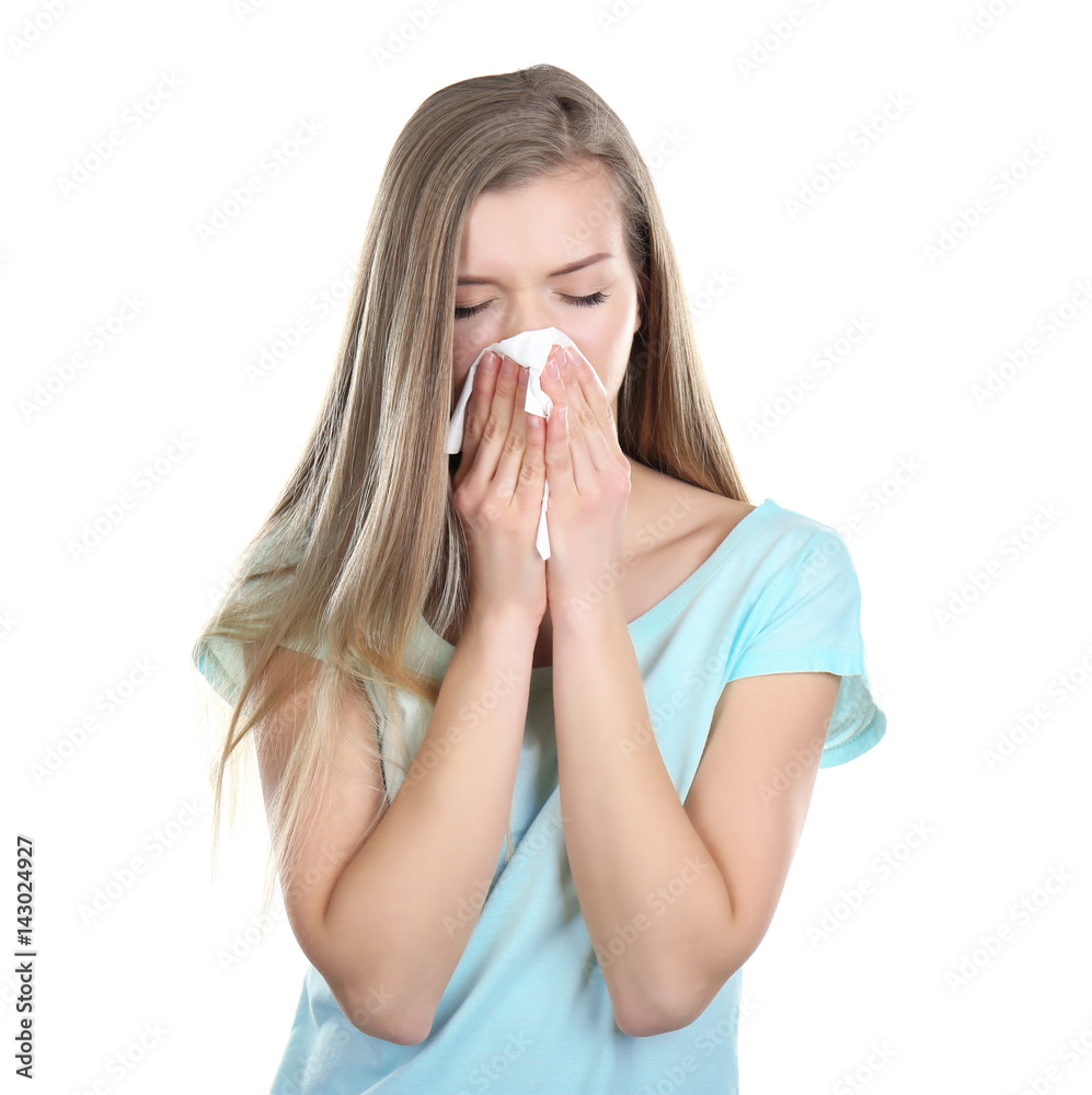 Young woman blowing nose on tissue against white background Young woman blowing nose on tissue against white background
