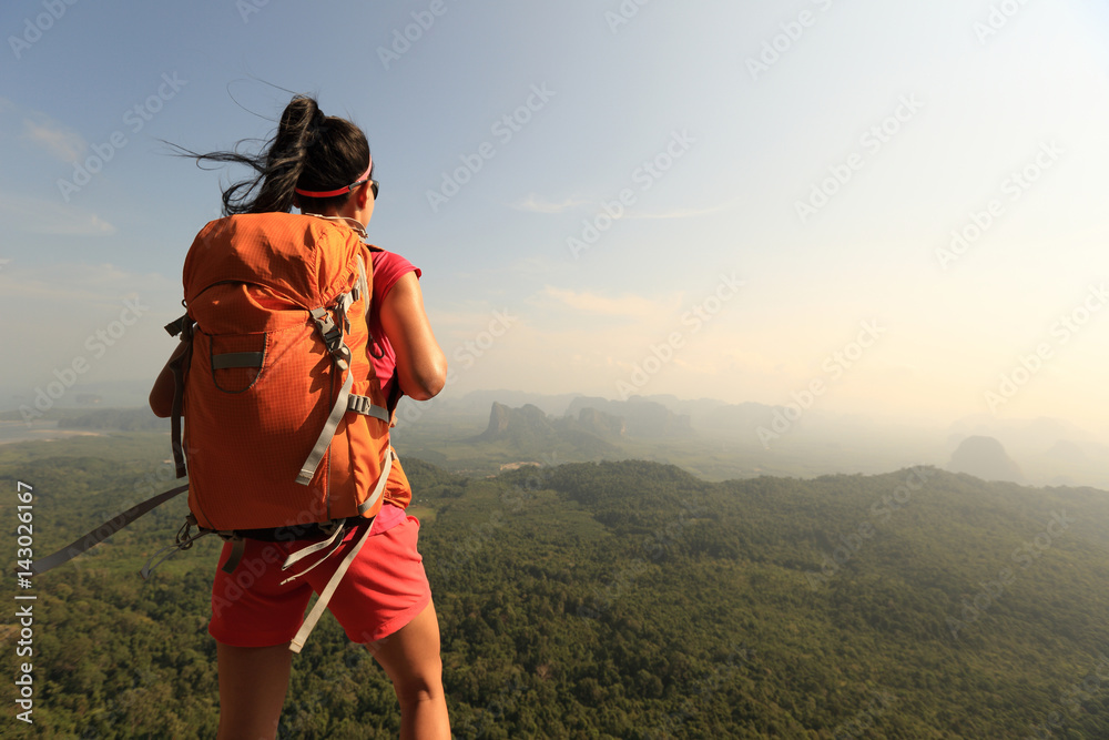 successful woman hiker enjoy the view on mountain top