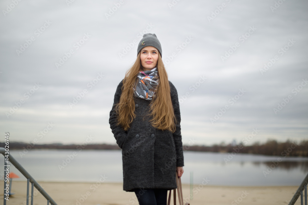 Portrait of a beautiful girl in early spring outdoors by the water Portrait of a beautiful girl in early spring outdoors by the water