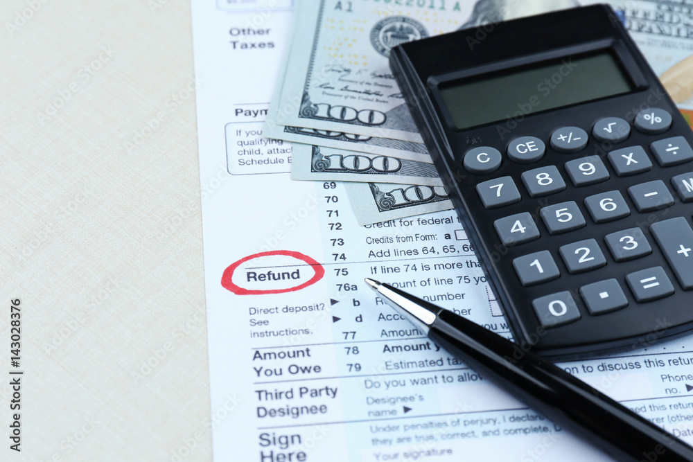 Tax form, calculator and dollars on table Tax form, calculator and dollars on table
