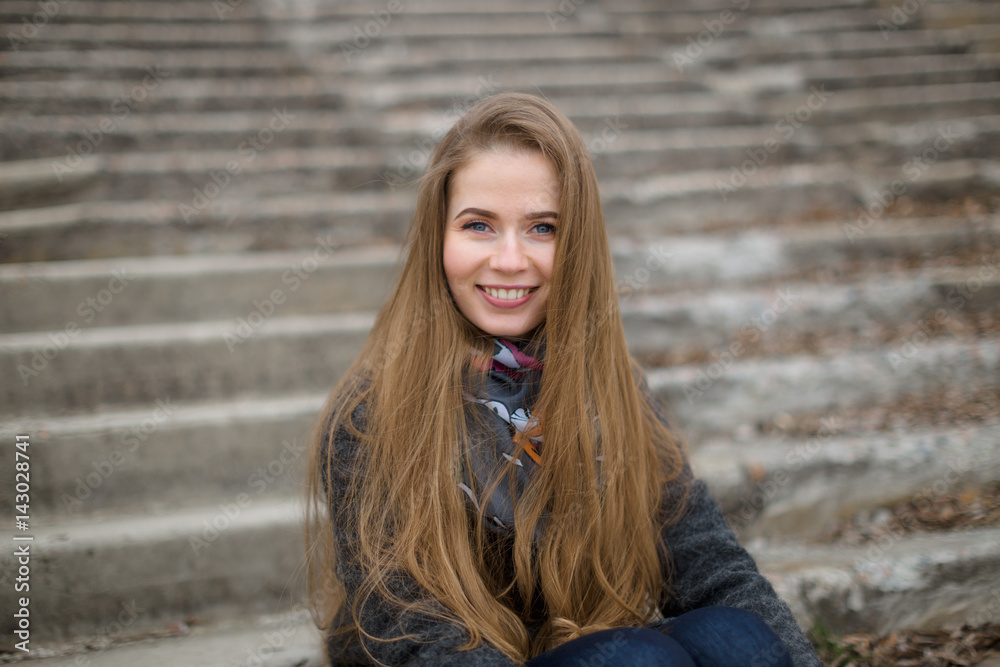 Portrait of a beautiful girl in early spring on the steps Portrait of a beautiful girl in early spring on the steps