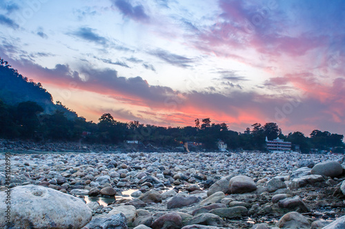 View of River Ganga and lots of stones after sunset with amazing dramatic sky. Rishikesh. India.