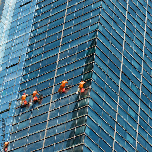 Obraz na plátne Workers of steeplejack washing windows of the modern building.