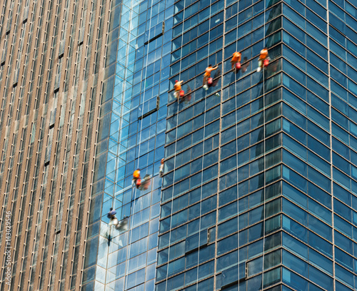 Tableau sur toile Workers of steeplejack washing windows of the modern building.