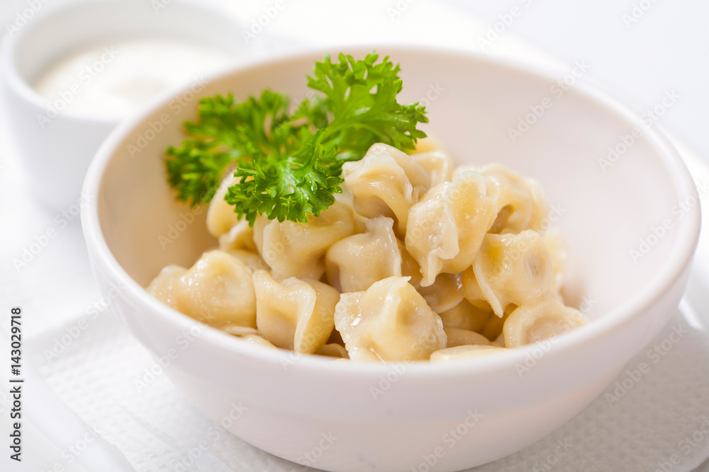 Meat dumplings - russian pelmeni, ravioli with meat in a deep bowl