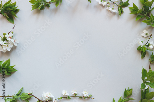 Spring tender background. Beautiful fresh flowers and leaves on gray background