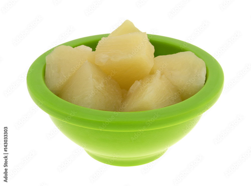 Pineapple chunks in a green bowl isolated on a white background. Pineapple chunks in a green bowl isolated on a white background.
