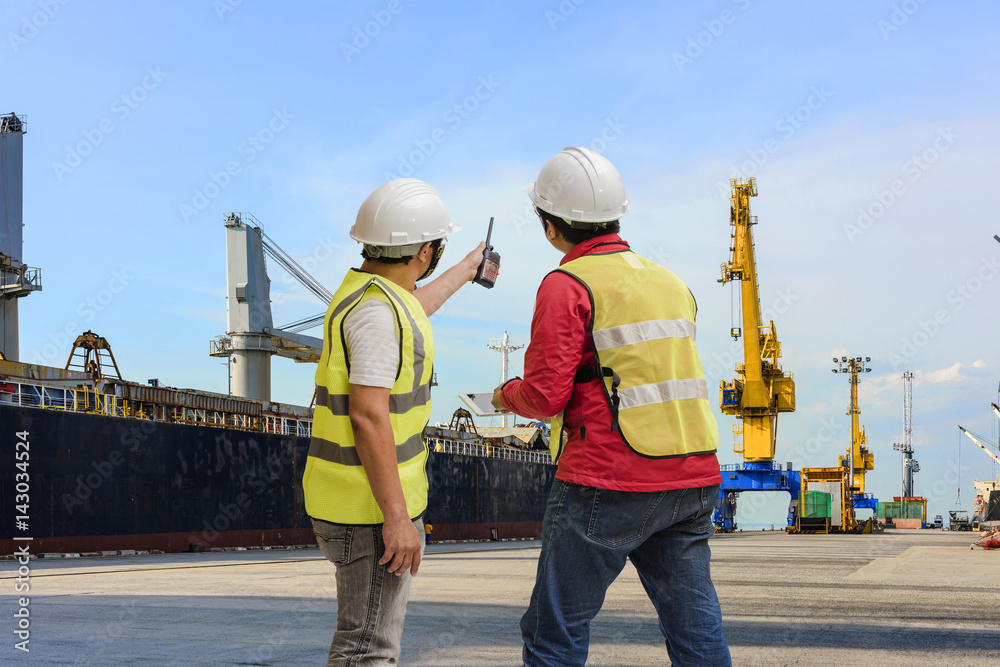 Port and safety controler surveying the port terminal with ship ...