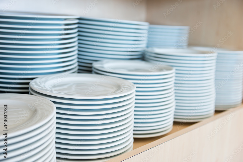 Group of white plates stacked together in a hotel. Group of white plates stacked together in a hotel.