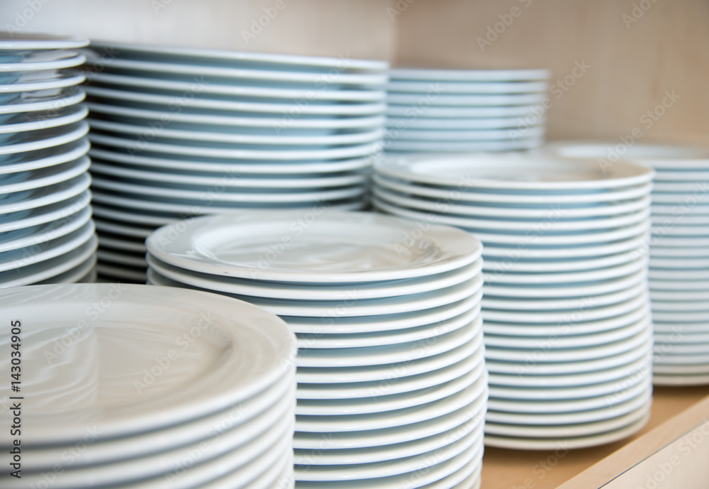 Group of white plates stacked together in a hotel. Group of white plates stacked together in a hotel.