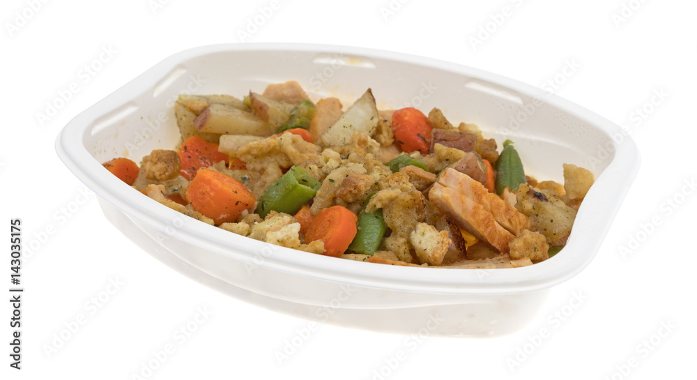 TV dinner of turkey breast with stuffing and vegetables isolated on a white background.