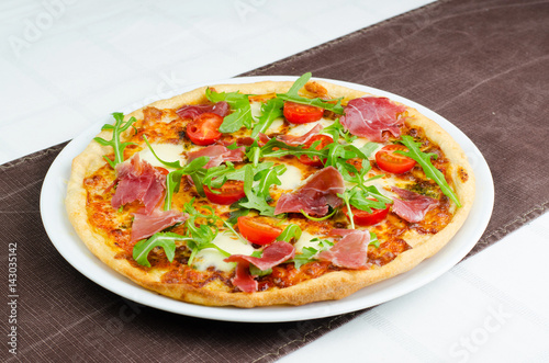 Tasty Italian Pizza With Prosciutto, Fresh Tomatoes And Arugula