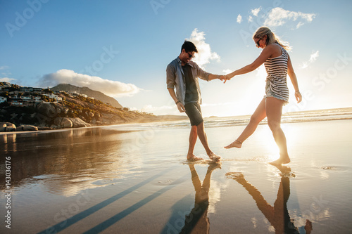 Beautiful young couple playing on the shore
