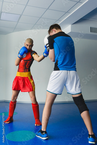 Two boxing men exercising together at the health club