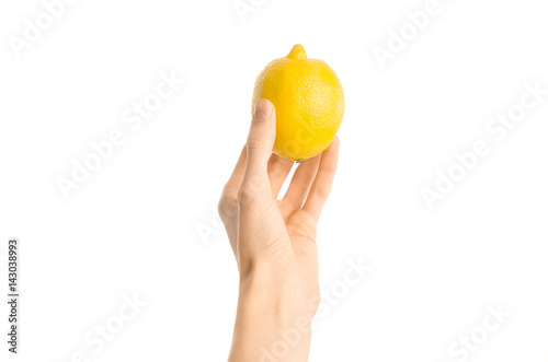 Healthy eating and diet Topic: Human hand holding yellow lemon isolated on a white background in the studio, first-person view