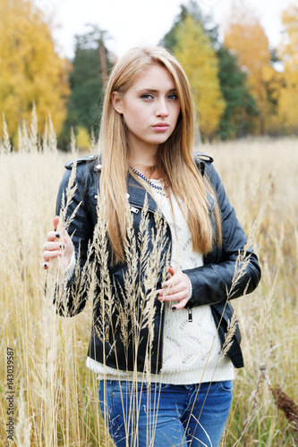 The girl in a leather jacket among a yellow grass © sergey makarenko