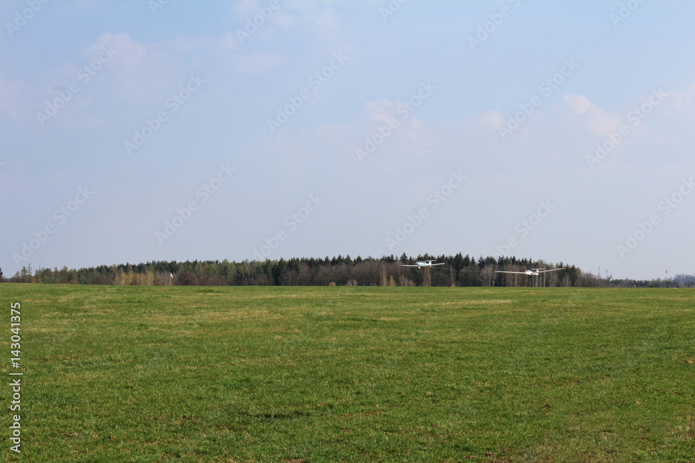 Ultralight plane pull glider to sky with forest in background